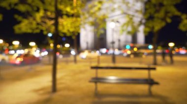 Paris 'teki Zafer Takı' nın önünden geçen yoğun bir trafik var. Şehrin işlek caddesinde tarihi Fransız simgesinin bulanık gece manzarası