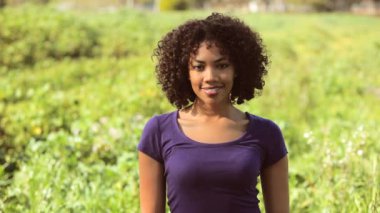 Genç kadın tarlada gülüyor.