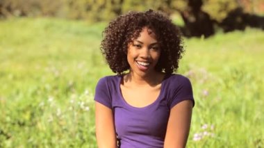 Genç kadın tarlada gülüyor.