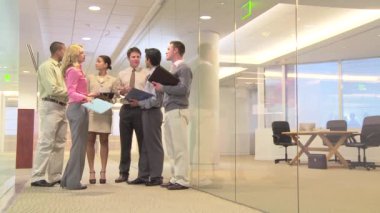 Ofis çalışanları koridorda toplanıyor.