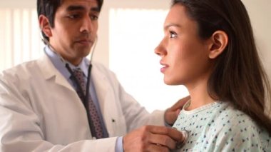 Meksikalı doktor kadının kalp atışlarını dinliyor.