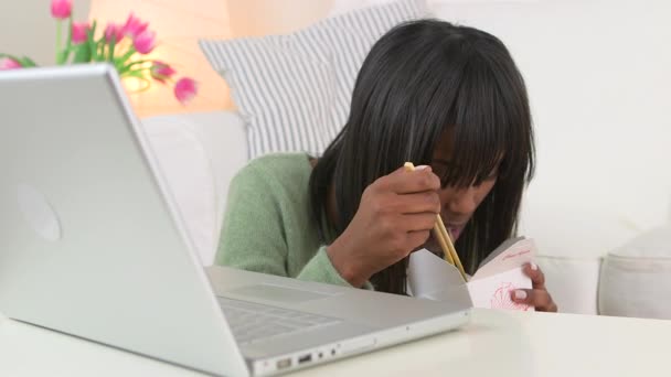 Çin Yemeği Yiyen Siyahi Kadın Dizüstü Bilgisayar Kullanırken Yemek Yiyor — Stok video