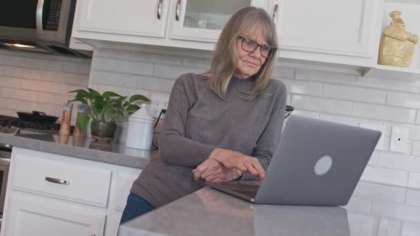 Üst Düzey Beyaz Bir Kadının Mutfaktaki Dizüstü Bilgisayarda Posta Okuduğu — Stok video