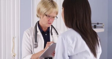 Kıdemli Doktor hastaya konuşurken tablet üzerinde notlar almak