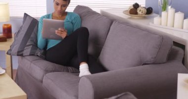 Siyah kadın tablette internette sörf yapıyor.