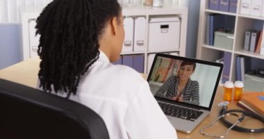 Siyahi kadın, Afrikalı Amerikalı doktorla görüntülü sohbet üzerinden konuşuyor.