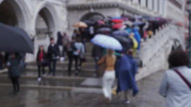 Venedik, İtalya 'da köprü basamaklarında yürüyen turistler, holdinglerin şemsiyeleri arasında. Yağmur fırtınası sırasında kemerli köprüde yaya trafiği. 4k