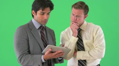 İş adamı elinde tabletle iş arkadaşıyla yeşil ekranda konuşuyor.