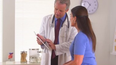 Doktor onunla birlikte röntgen taramalarını inceliyor.