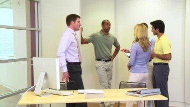 Bir grup iş arkadaşı ofiste ayakta ve konuşuyorlar.