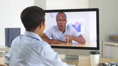 Kızgın iş adamı bilgisayardan iş arkadaşıyla konuşuyor.