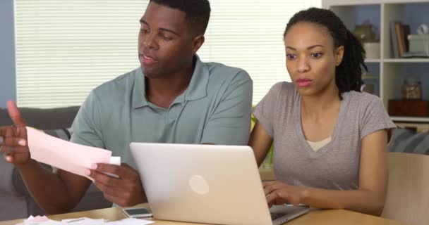 ラップトップ コンピューターでオンライン支払い深刻な若い黒人カップル — ストック動画