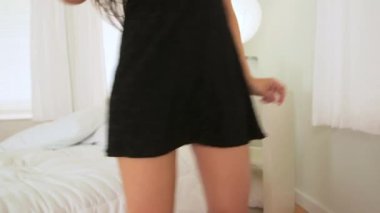 Siyah elbiseli İspanyol kadın yatak odasında dans ediyor.