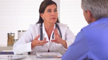 Doktor, erkek hastaya daha sağlıklı bir yaşam tarzının nasıl olması gerektiği konusunda tavsiyede bulunuyor.