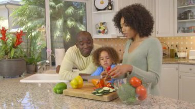 Afro-Amerikan ailesi mutfakta sebze doğruyor.