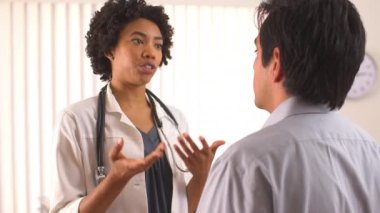 Kadın doktor İspanyol hastayla konuşuyor.