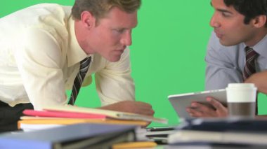 İş adamı elinde tabletle iş arkadaşıyla yeşil ekranda konuşuyor.