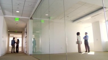 İş adamları ve iş kadınları ofis koridorunda ve ofiste buluşuyorlar.