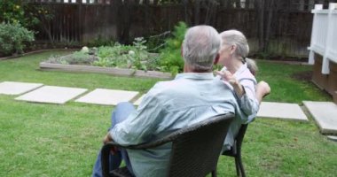 Bahçede oturan olgun bir çift.