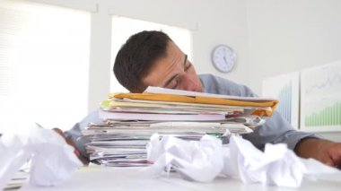 İşadamı kağıt yığınında uyuyor.