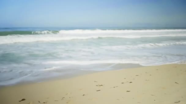 阳光灿烂的日子里 波浪在加利福尼亚海滩上冲刷着 寻找绿色的屏风或彩色的钥匙 因创作或键入而失去焦点或注意力分散 — 图库视频影像