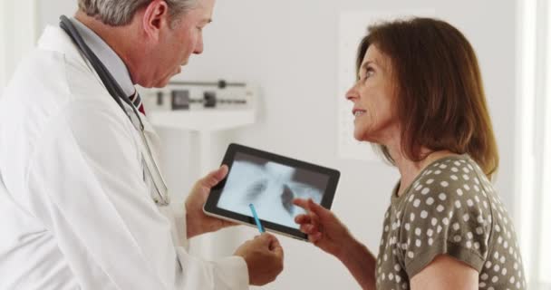 资深医生向年长病人解释肺X光检查结果 — 图库视频影像