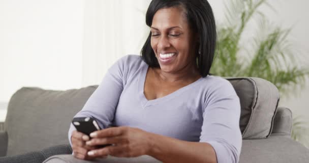 熟女黒人女性のテキストスマートフォン笑い — ストック動画
