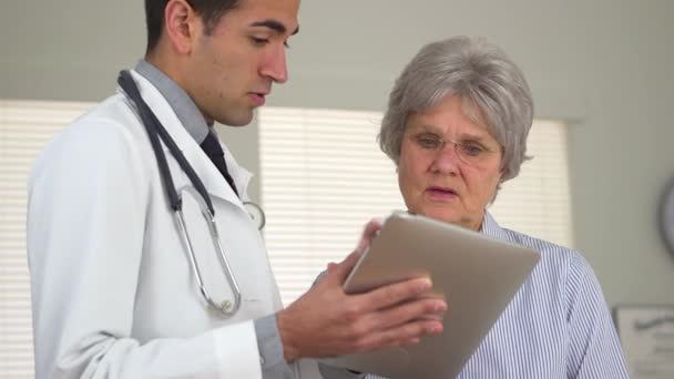 Médico Hispano Hablando Con Mujer Madura Con Tableta — Vídeos de Stock