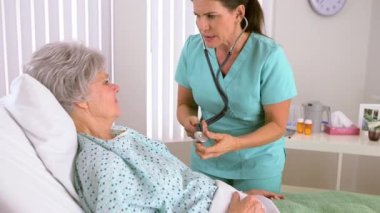 Başhemşire hasta kalbinin sesini dinliyor.