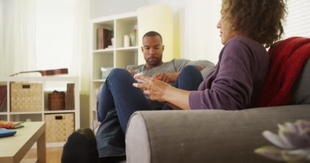 African American Couple Using Devices Couch — Stock Video