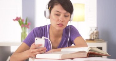 Ödev yaparken müzik dinleyen Çinli kadın.