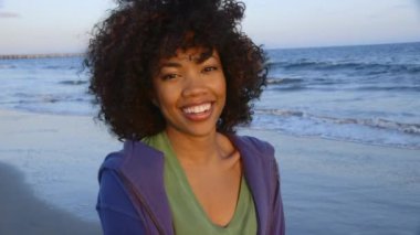 Sahilde utanmış gibi davranan kadın portresi.