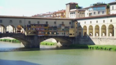 İtalya 'daki Arno Nehri üzerindeki Ponte Vecchio köprüsünün güneşli manzarası. Floransa İtalya 'nın tarihi manzarası
