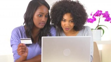 İki Afrikalı Amerikalı arkadaş online alışveriş yapıyorlar.