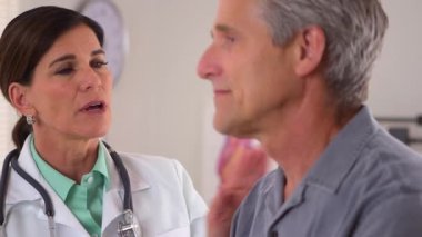 Yaşlı bir hastayla ilgilenen doktor konuşuyor.