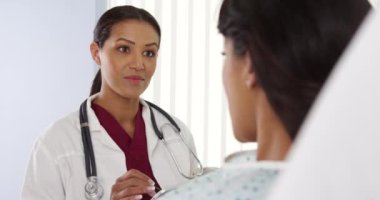 Afro-Amerikan Doktor tablet bilgisayarlı hastayla konuşuyor.