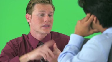 Yeşil ekranda konuşan iki iş adamının omzunun üstünden.