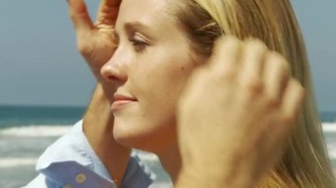 Okyanusun kenarında öpüşen çiftlere yakın.