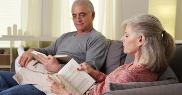 Senior Couple Sitting Couch Reading Books — Stock Video