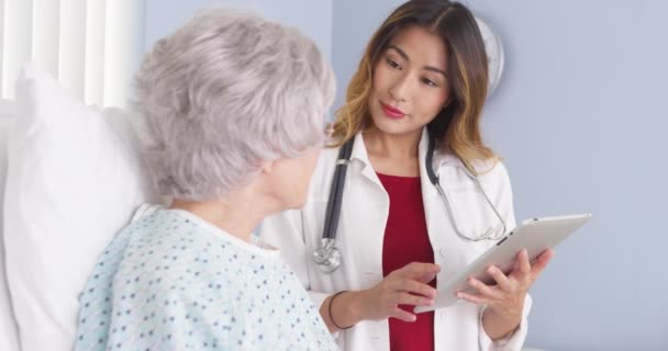 Japansk Läkare Som Använder Tablettdator Och Talar Med Äldre Patienter — Stockvideo