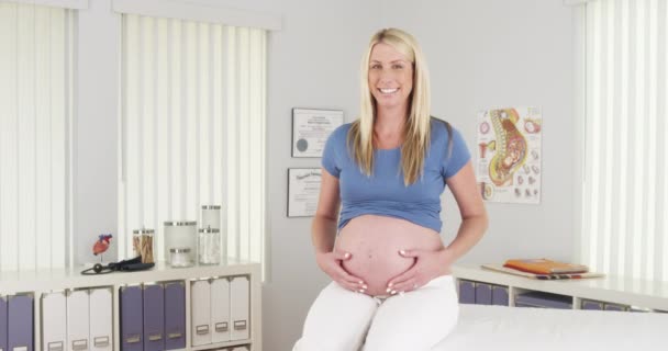 Szczęśliwa Kobieta Ciąży Siedzi Gabinecie Lekarskim — Wideo stockowe