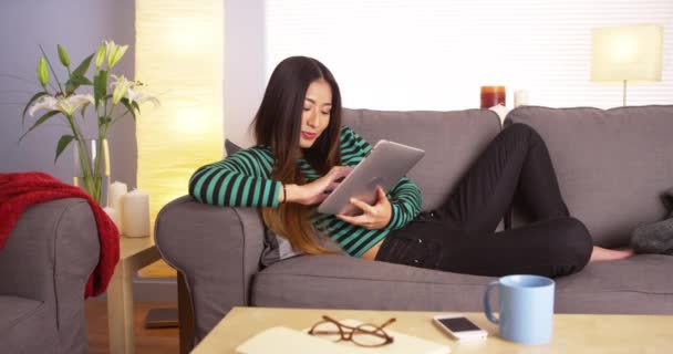 Niedliche Japanerin Mit Tablet Auf Der Couch — Stockvideo