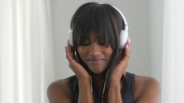 Mutlu siyah kadın müzik dinliyor ve gülümsüyor.