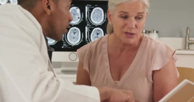 Tıbbi ofisteki tablet bilgisayara bakan doktor ve hastaya yakından bakın. Doktorla oturup elektronik tablete bakan yaşlı kadın hasta portresi.