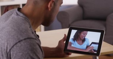 İş arkadaşı ile tablet üzerinde konuşan siyah adam