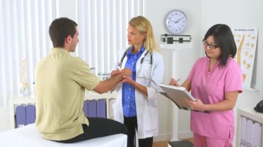 Doktor hastanın bileğini muayene ediyor.