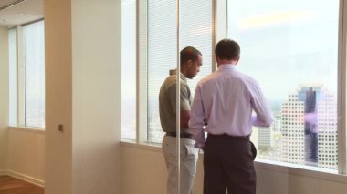 Ofis penceresinden şehre bakan iş adamları