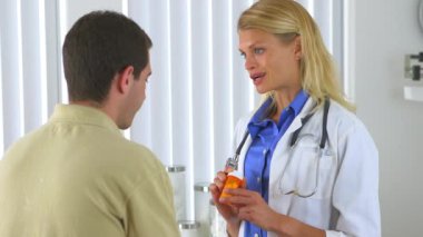 Kafkasyalı doktor erkek hastaya ilaç yazıyor.