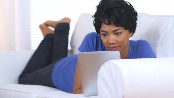 Schwarze Frau Benutzt Laptop Während Sie Auf Couch Liegt — Stockvideo
