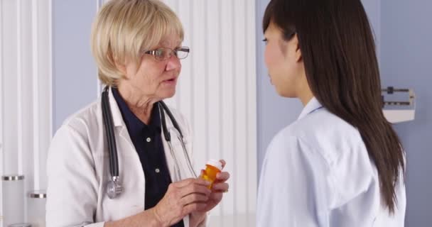 中国人の患者に薬を説明する先輩医師 — ストック動画